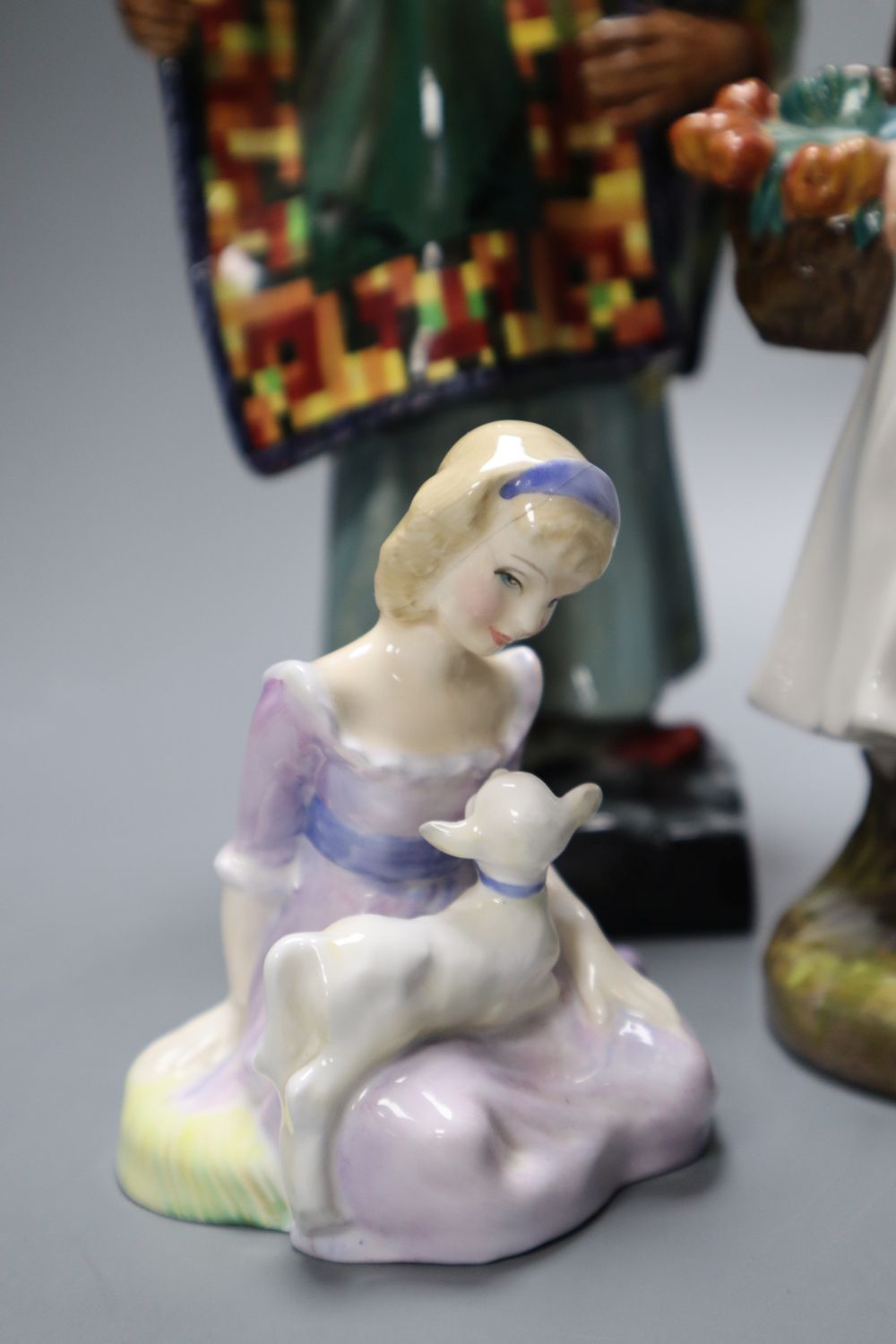 Four Royal Doulton figures, Carpet Seller, Mask Seller, Country Lass, Mary had a Little Lamb